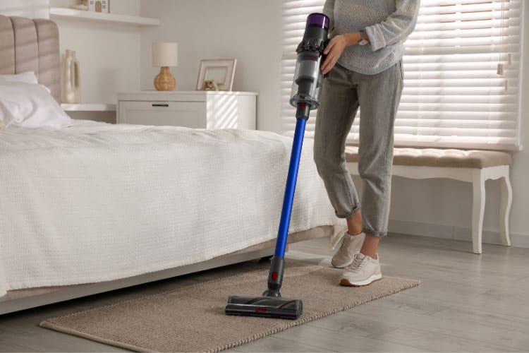 A cordless stick vacuum stands charged in my closet at all times