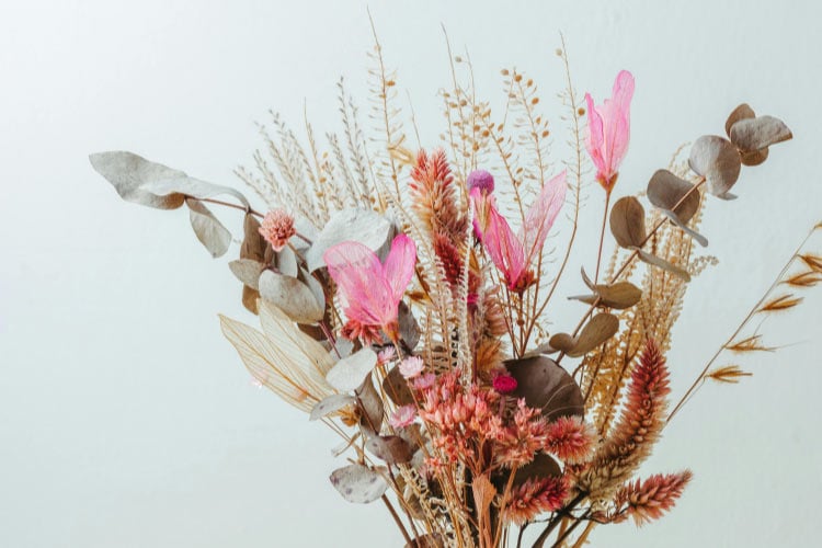 Dried greenery is even better because it offers a muted palette that does not overpower the rest of your decor