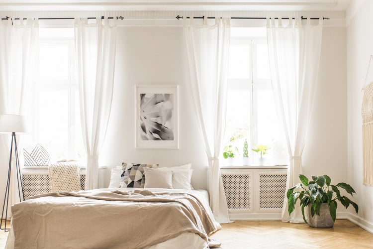 Hang your curtains close to the ceiling and let them drape all the way to the floor to make the room appear taller